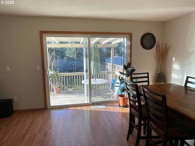 dining area with visible vents, baseboards, and wood finished floors