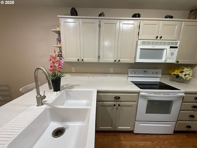 kitchen with dark wood finished floors, white appliances, open shelves, light countertops, and a sink