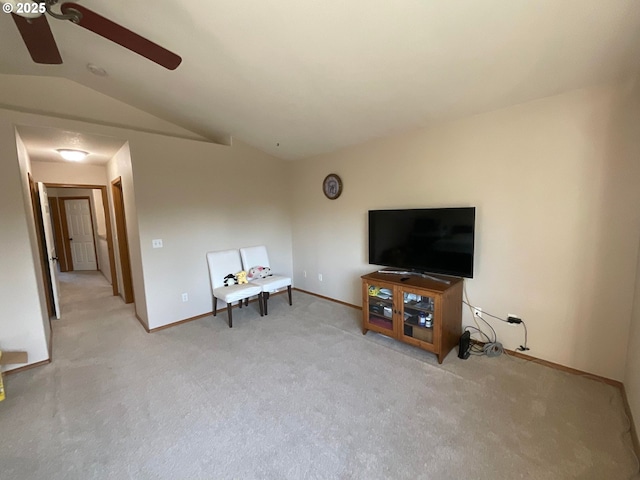 living area with baseboards, a ceiling fan, light colored carpet, and vaulted ceiling