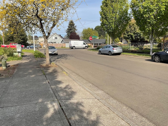 view of road featuring traffic signs, sidewalks, and curbs