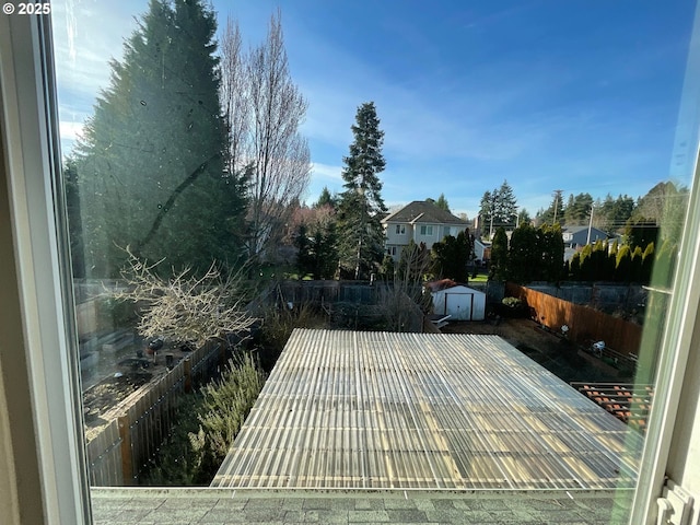 wooden terrace featuring a storage unit, fence, and an outdoor structure