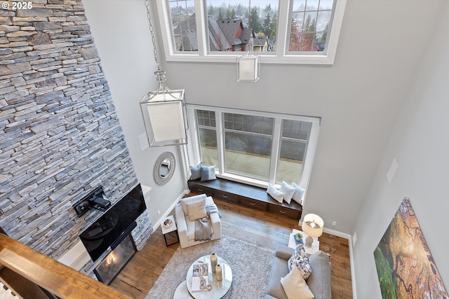 living area with plenty of natural light, baseboards, and wood finished floors