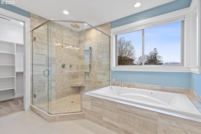 full bath with recessed lighting, a shower stall, a walk in closet, a garden tub, and tile patterned floors