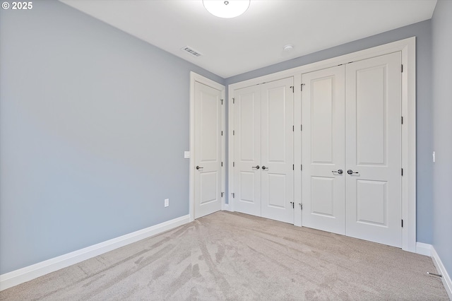 unfurnished bedroom featuring two closets, baseboards, visible vents, and carpet floors