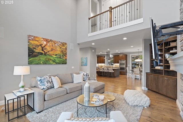 living room featuring recessed lighting, light wood-style flooring, and baseboards