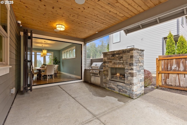 view of patio / terrace with grilling area, an outdoor stone fireplace, and fence