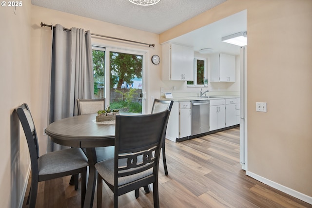 15580 SW Royalty Pkwy, Portland, OR 97224 - dining space with light wood finished floors, a textured ceiling, and baseboards