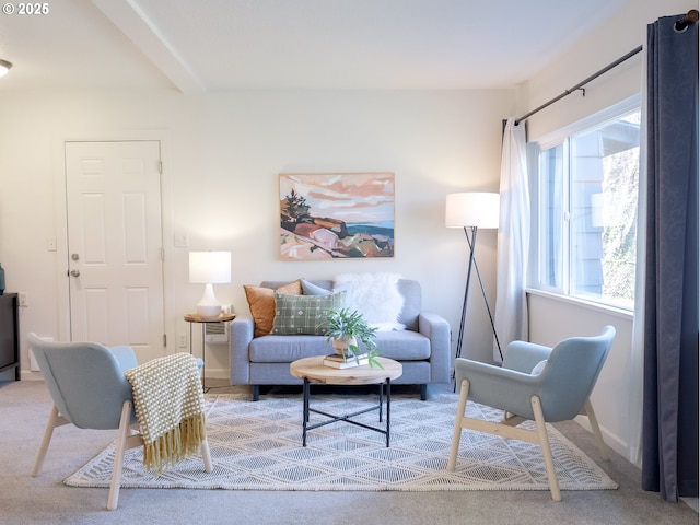 carpeted living room featuring beamed ceiling