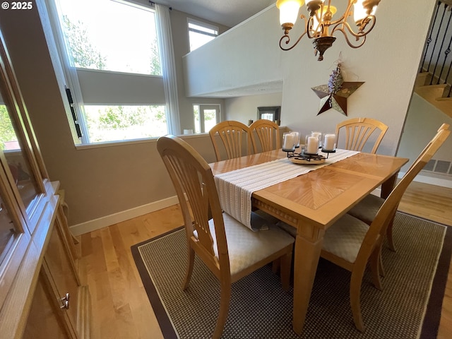 2145 Rock Ledge Dr, Keizer, OR 97303 - dining space with wood finished floors, a chandelier, and stairs