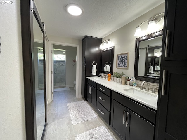 2145 Rock Ledge Dr, Keizer, OR 97303 - full bathroom featuring double vanity, a textured ceiling, and a shower