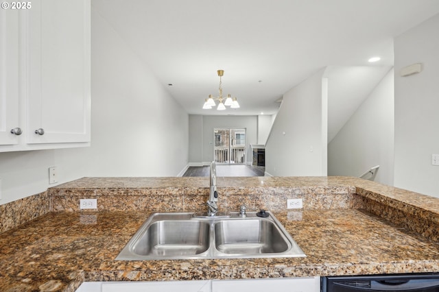 kitchen with sink, a notable chandelier, pendant lighting, dishwasher, and white cabinets