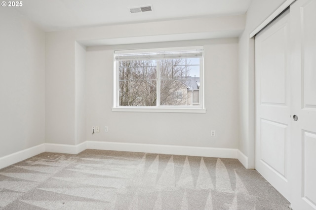 unfurnished bedroom featuring light carpet and a closet