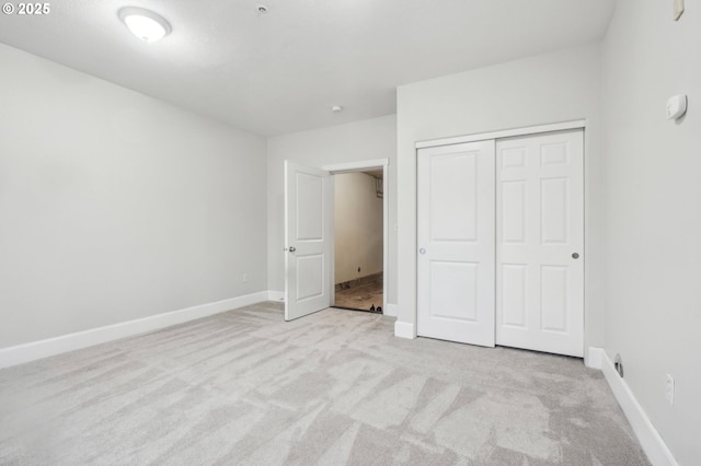 unfurnished bedroom with light carpet and a closet