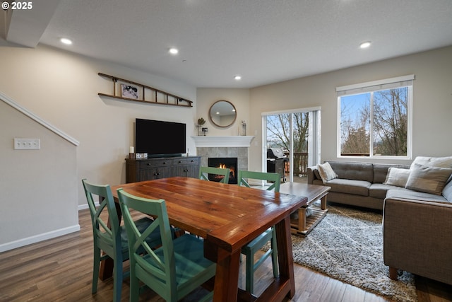 dining room featuring a tile fireplace and wood-type flooring