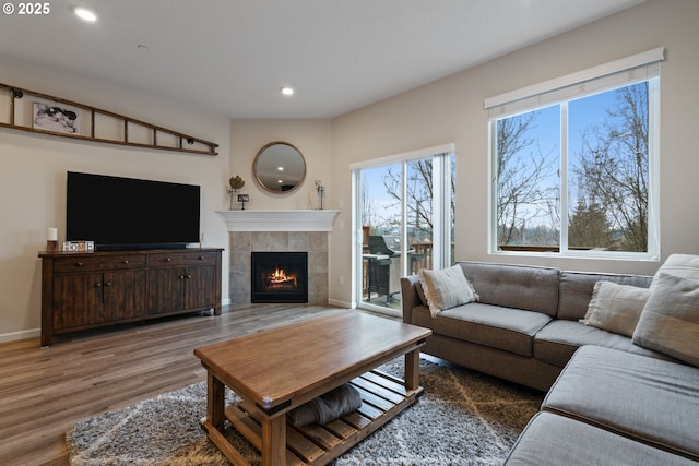 living room featuring a tile fireplace and hardwood / wood-style floors