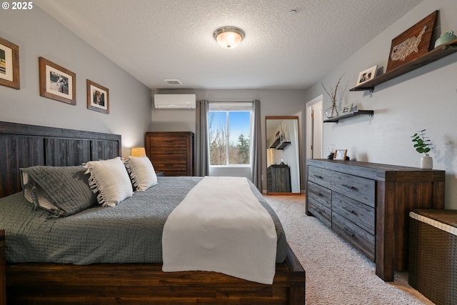 bedroom featuring a wall mounted AC, carpet floors, and a textured ceiling