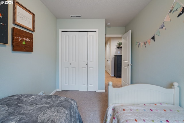 bedroom with a textured ceiling, a closet, and carpet