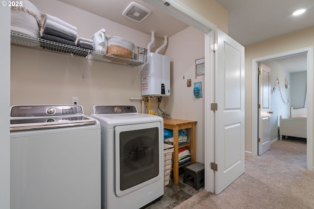 clothes washing area featuring light carpet, washing machine and dryer, and water heater