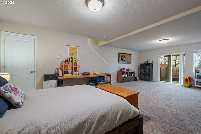 carpeted bedroom featuring a textured ceiling and access to exterior