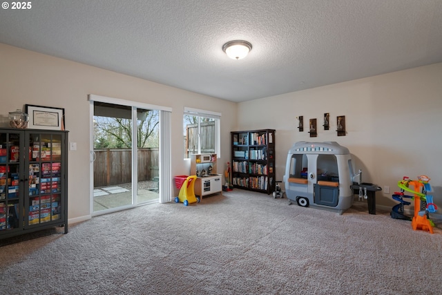 game room with a textured ceiling and carpet