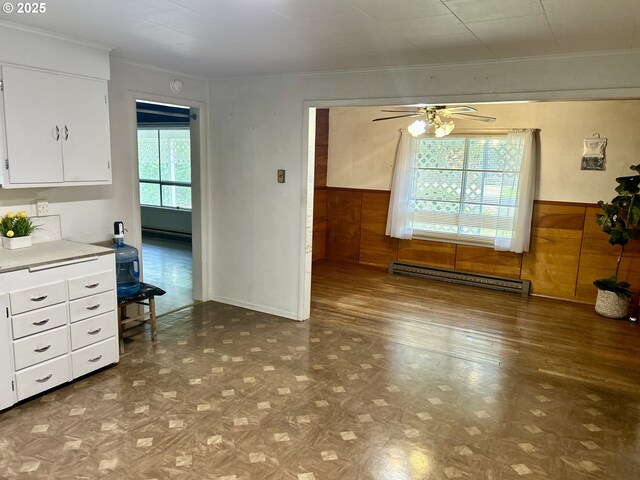21223 NW Bendemeer Rd, Hillsboro, OR 97124 - unfurnished dining area featuring a baseboard heating unit, a ceiling fan, wood finished floors, a wainscoted wall, and wooden walls