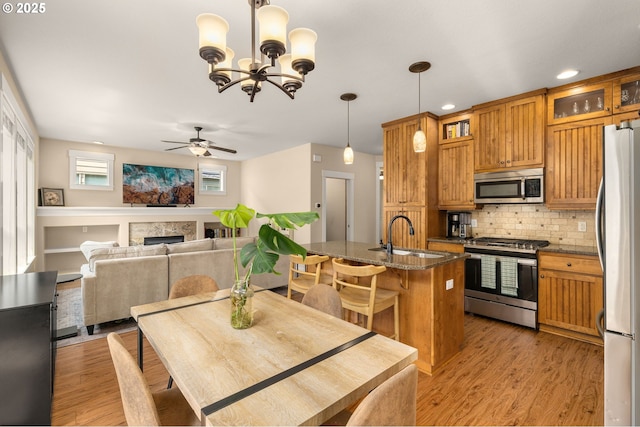 17760 SW Robert Ln, Beaverton, OR 97078 - dining area with ceiling fan, light wood finished floors, a fireplace, recessed lighting, and a chandelier