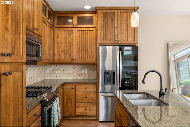 17760 SW Robert Ln, Beaverton, OR 97078 - kitchen with appliances with stainless steel finishes, brown cabinets, dark stone counters, and backsplash