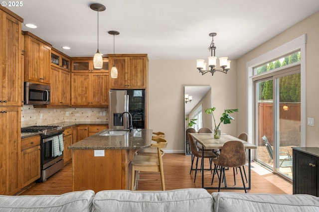 17760 SW Robert Ln, Beaverton, OR 97078 - kitchen featuring appliances with stainless steel finishes, backsplash, brown cabinets, a chandelier, and recessed lighting