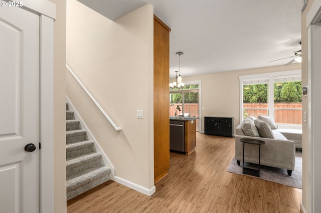 17760 SW Robert Ln, Beaverton, OR 97078 - stairs featuring wood finished floors, a ceiling fan, and a chandelier