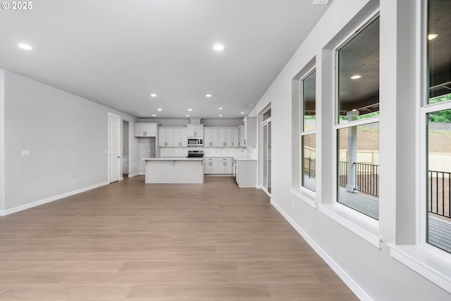 1624 NE Josephine Ct Unit 177, Estacada, OR 97023 - unfurnished living room featuring light wood finished floors, recessed lighting, baseboards, and a sink
