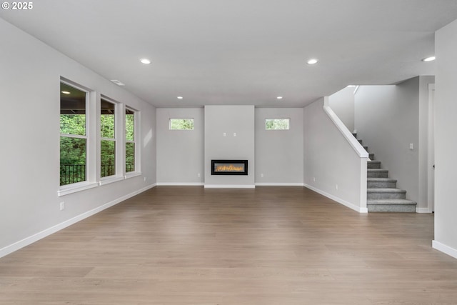 1624 NE Josephine Ct Unit 177, Estacada, OR 97023 - unfurnished living room featuring baseboards, light wood finished floors, stairs, recessed lighting, and a glass covered fireplace