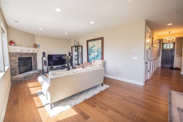 living area with a chandelier, recessed lighting, wood finished floors, visible vents, and baseboards