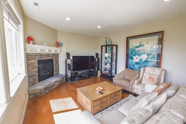 living area with a fireplace, wood finished floors, visible vents, and recessed lighting