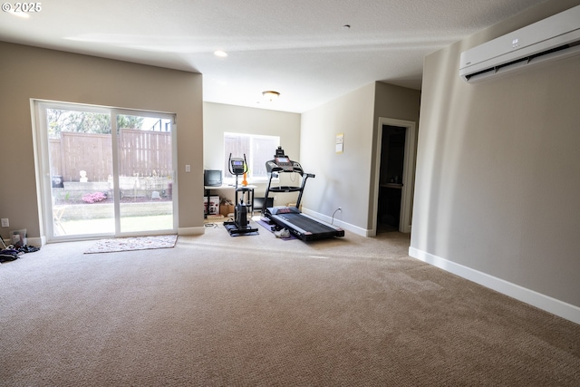 exercise area featuring carpet, a wall unit AC, and baseboards