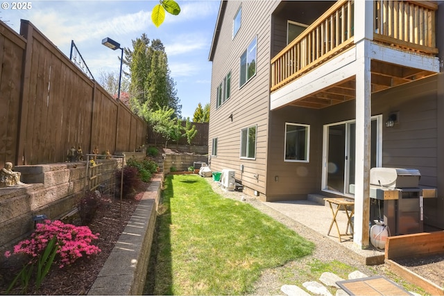 view of yard featuring a patio, a fenced backyard, and a balcony