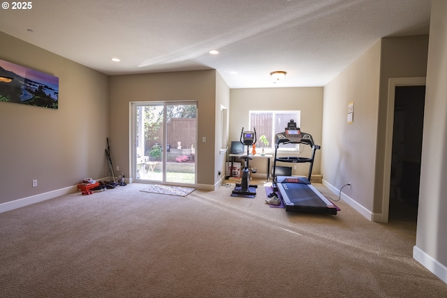 exercise area featuring a textured ceiling, baseboards, carpet flooring, and recessed lighting