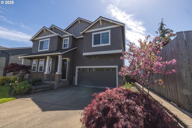 craftsman-style home featuring concrete driveway, board and batten siding, fence, a garage, and stone siding