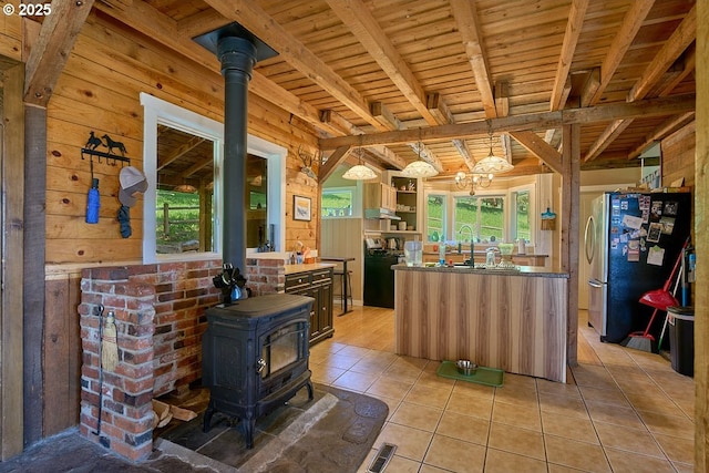 83863 Ollokot Ln, Joseph, OR 97846 - kitchen featuring freestanding refrigerator, a wood stove, healthy amount of natural light, a sink, and wooden walls