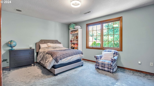 bedroom with carpet floors and a textured ceiling