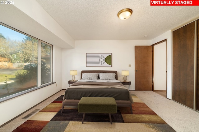 bedroom with a textured ceiling and carpet