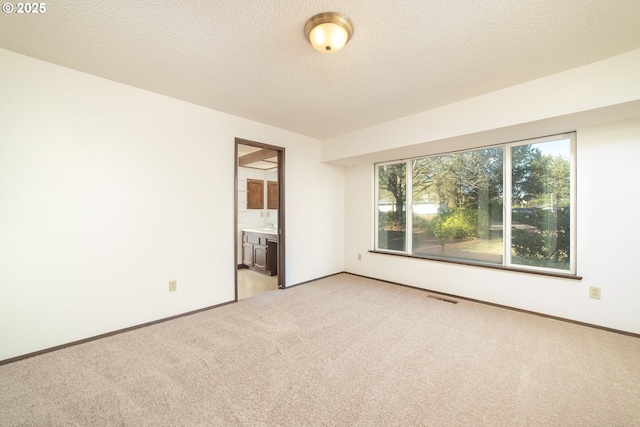 carpeted empty room with a textured ceiling