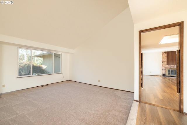 empty room with hardwood / wood-style flooring and lofted ceiling