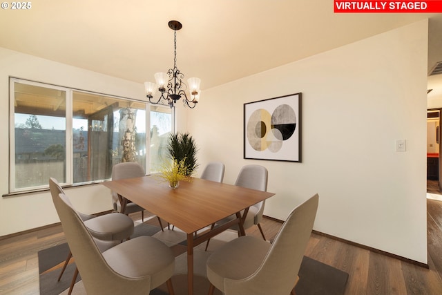 dining area with dark wood-type flooring and a chandelier