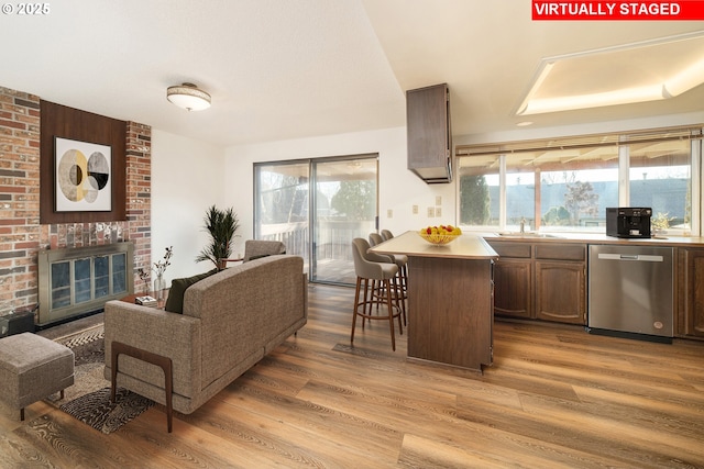 living room with wood-type flooring, a fireplace, and sink