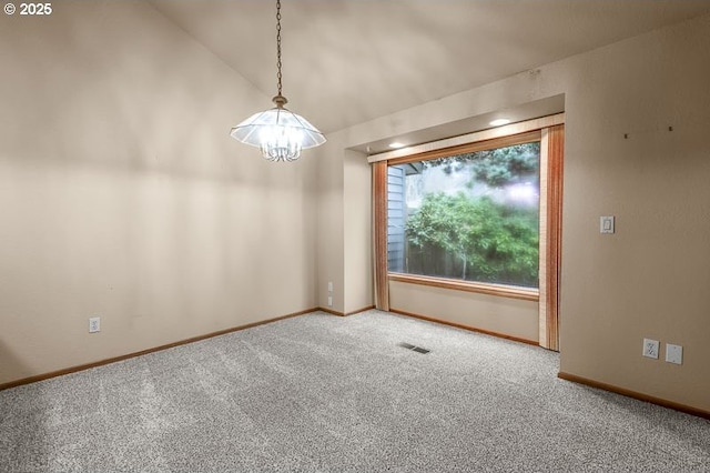 spare room featuring carpet floors, lofted ceiling, and a chandelier