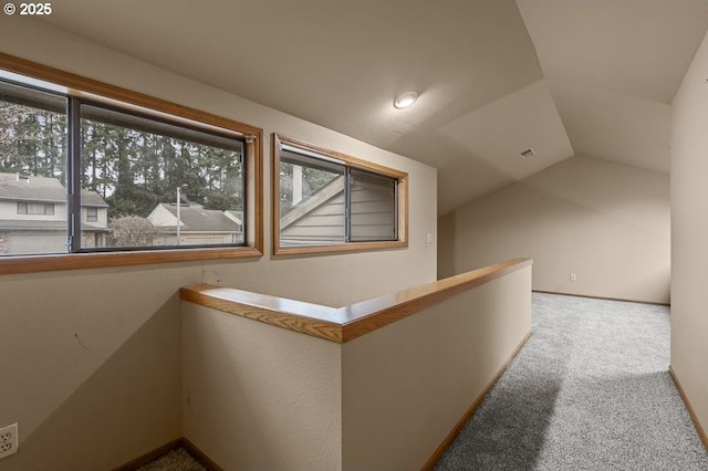 hall featuring lofted ceiling and carpet flooring