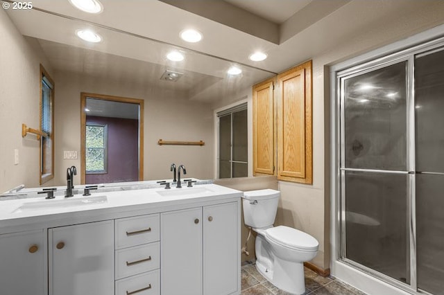 bathroom with a shower with door, toilet, and vanity