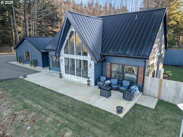 back of house with a yard, an outdoor living space, and a patio area