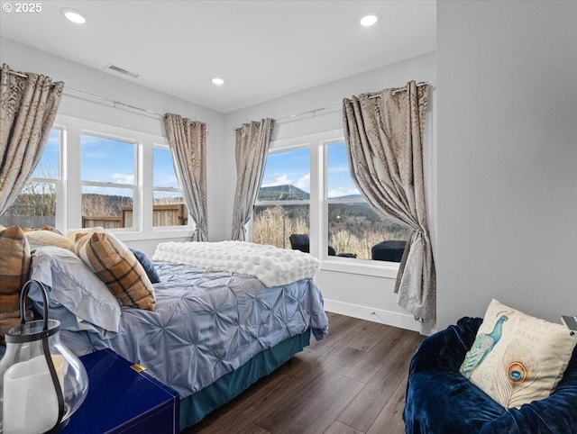 bedroom featuring dark hardwood / wood-style flooring and a mountain view