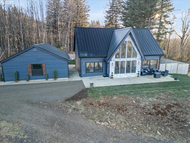 rear view of property with an outdoor hangout area, an outdoor structure, and a patio